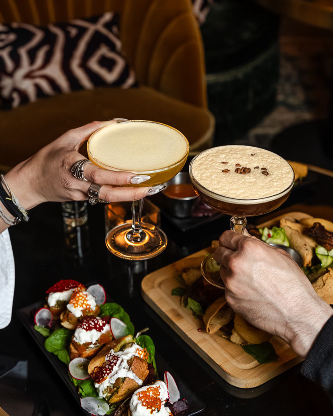 Deux cocktails servis à table avec des assiettes à partager
