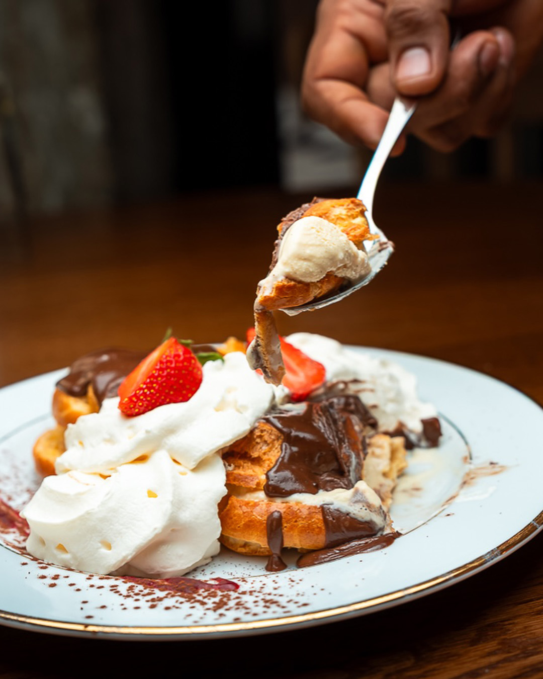 Dessert gourmand avec crème, chocolat et fraises servi à la cuillère