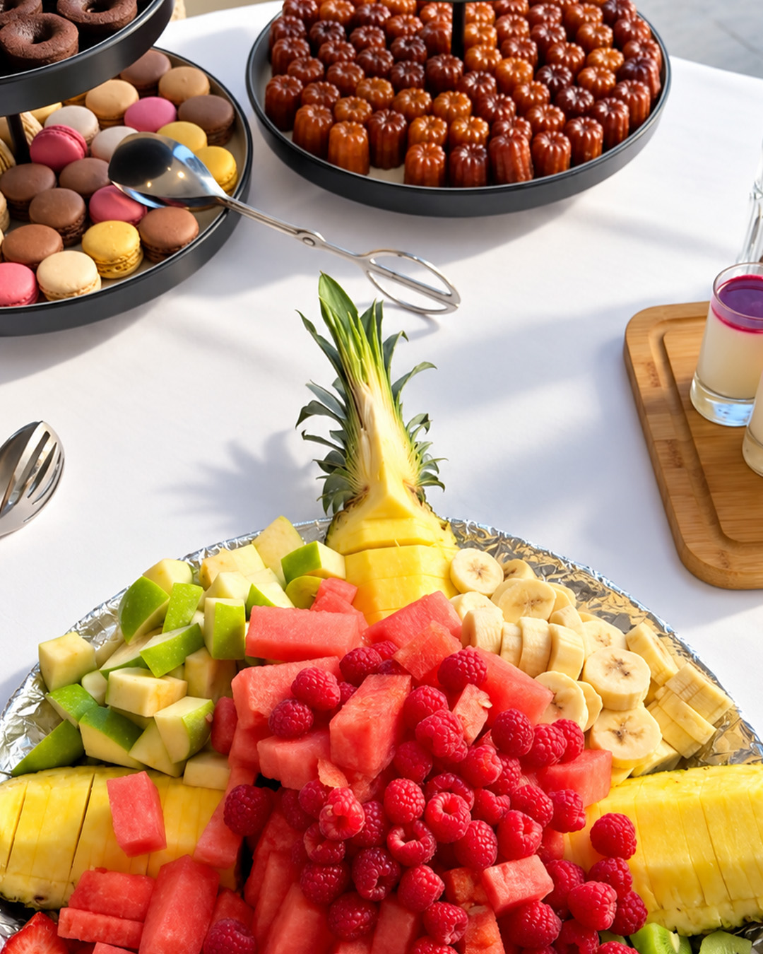 Buffet de brunch avec fruits frais, macarons et cannelés